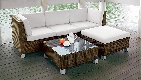 immagine di un bellissimo divano da giardino con tavoli abinati e cuscini protettivi