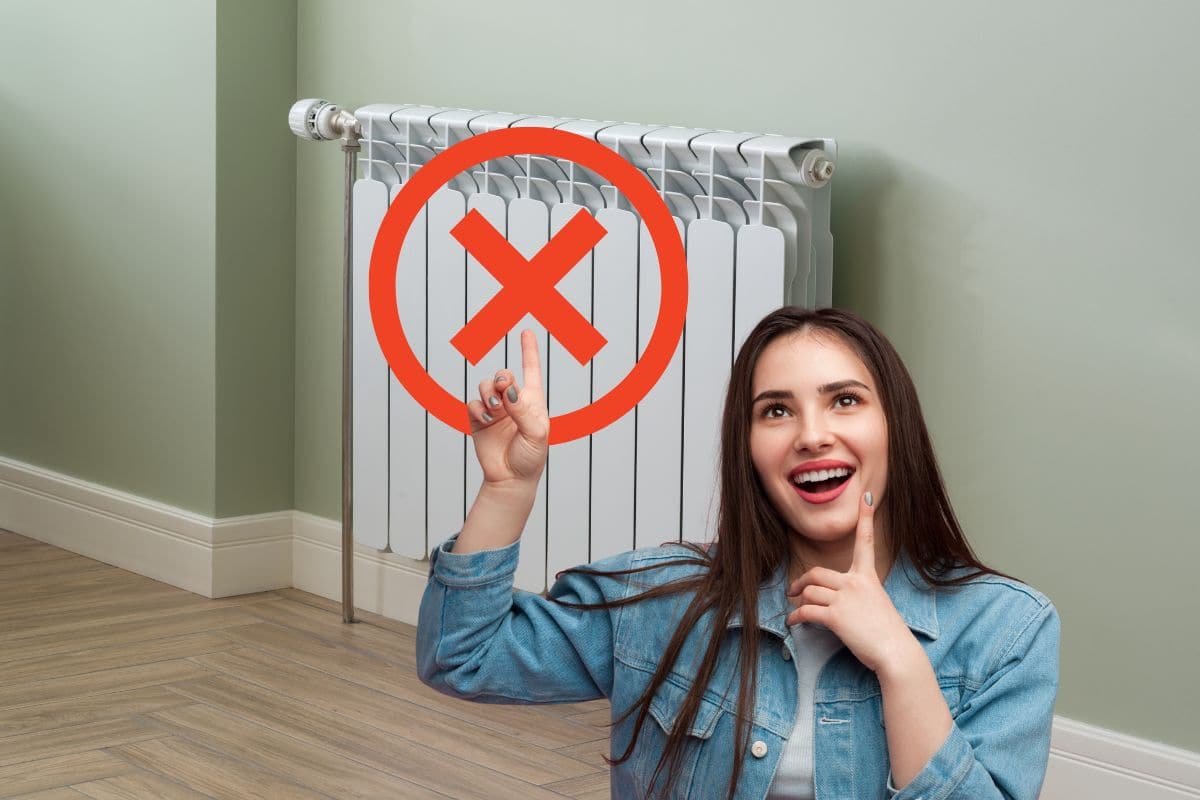 termosifone con segno x rosso sopra e donna sorpresa che lo indica