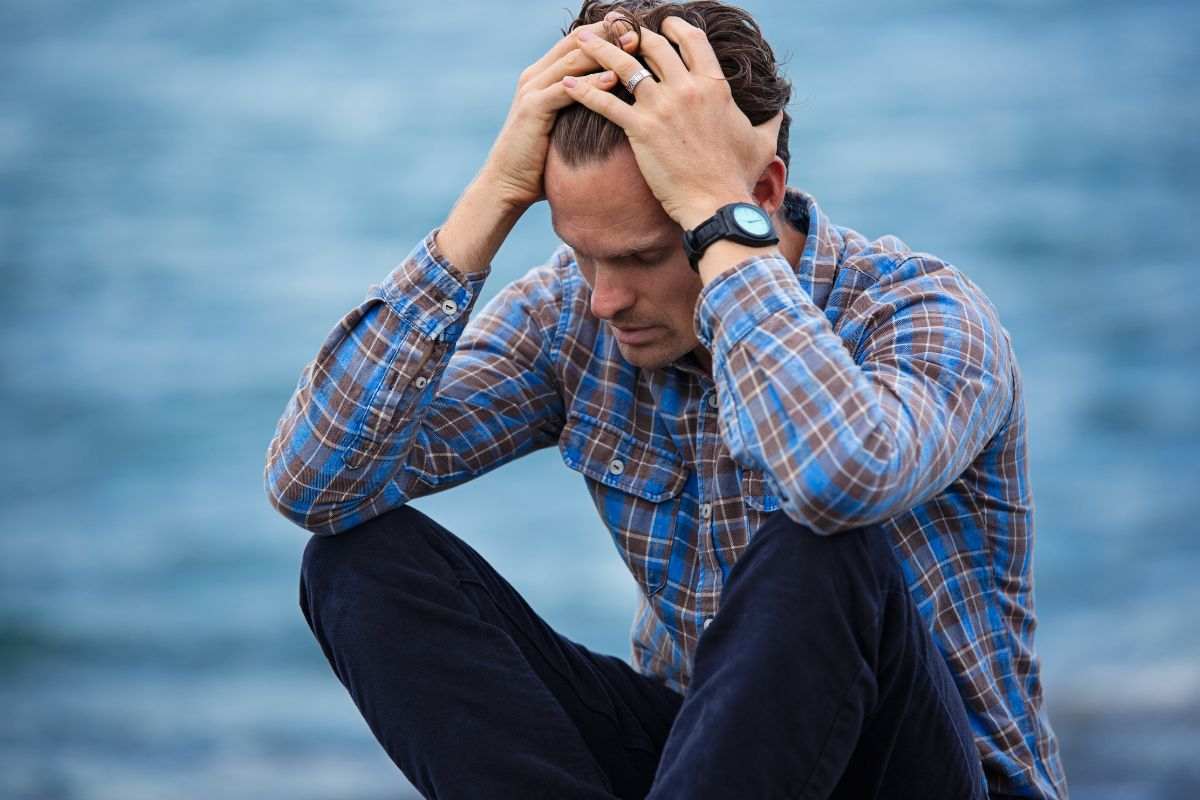 Uomo disperato con le mani tra i capelli